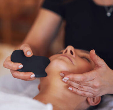 Brunette woman having a stone massage on face. High quality photo
